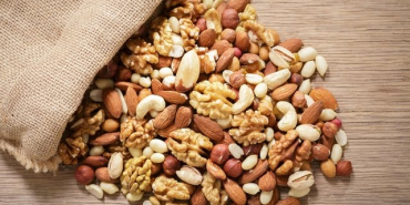Close,Up,Of,Sack,Of,Mixed,Nuts,On,Wooden,Table,
